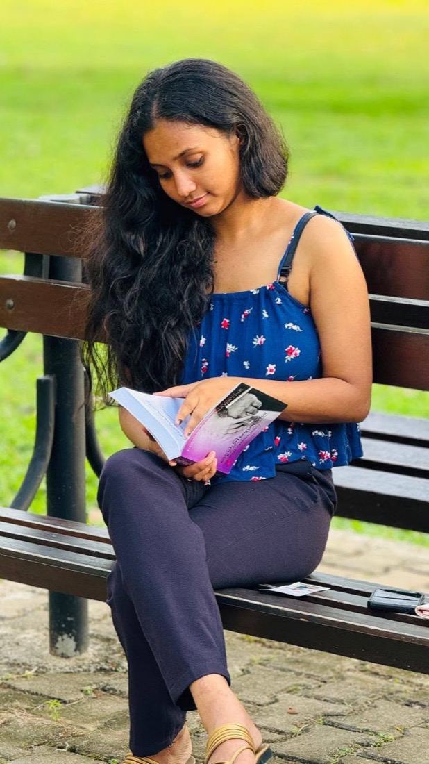 Thaara reading a book on a park bench