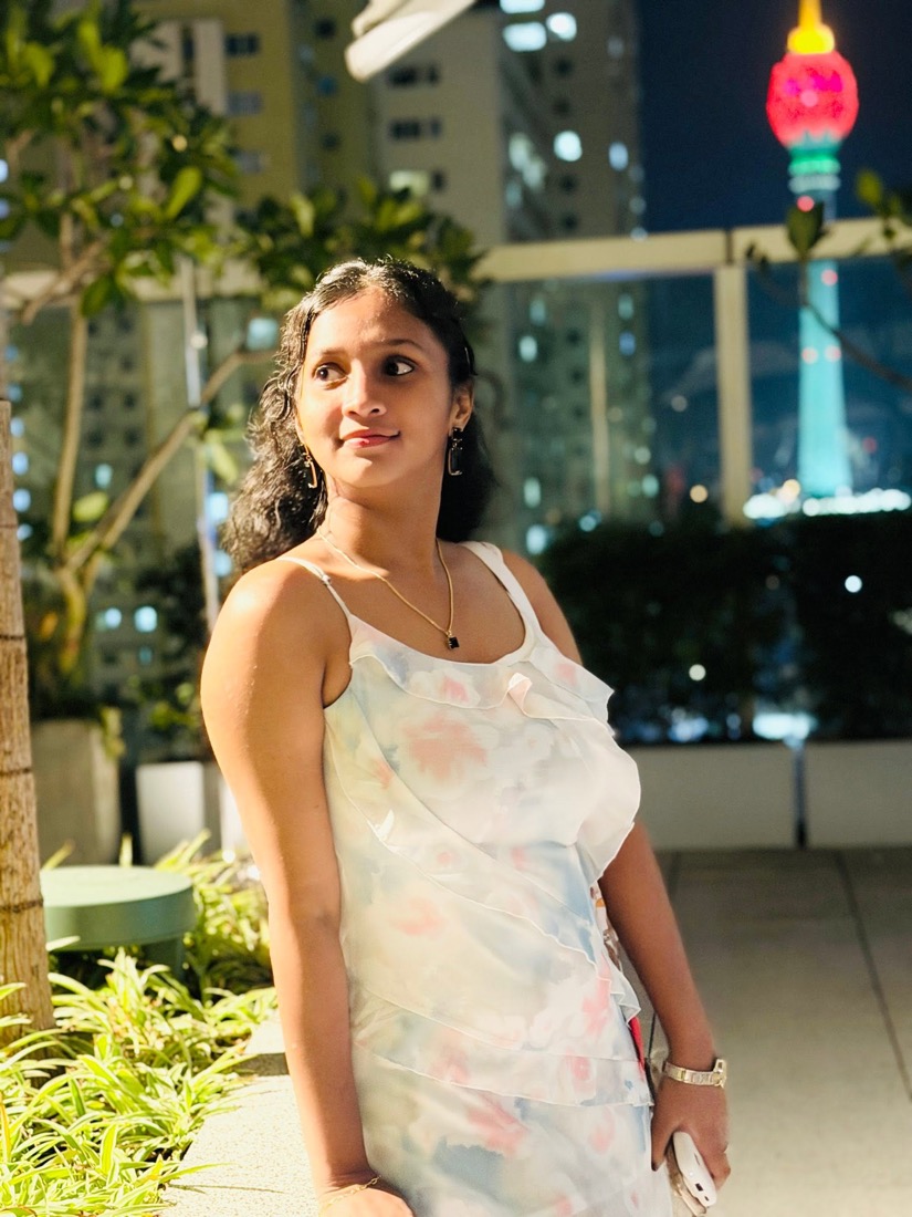 Thaara at night with city lights behind her